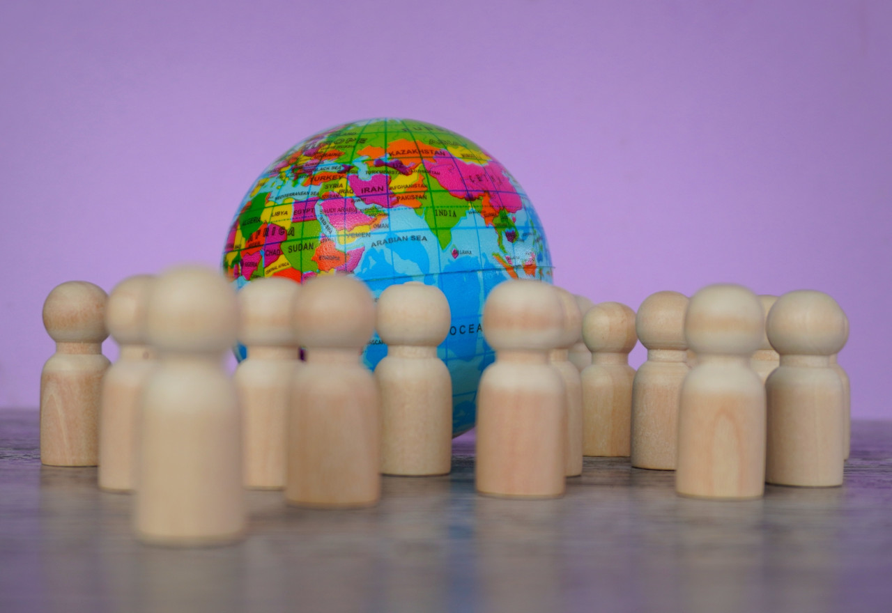 Wooden dolls and earth globe. World Population Day concept