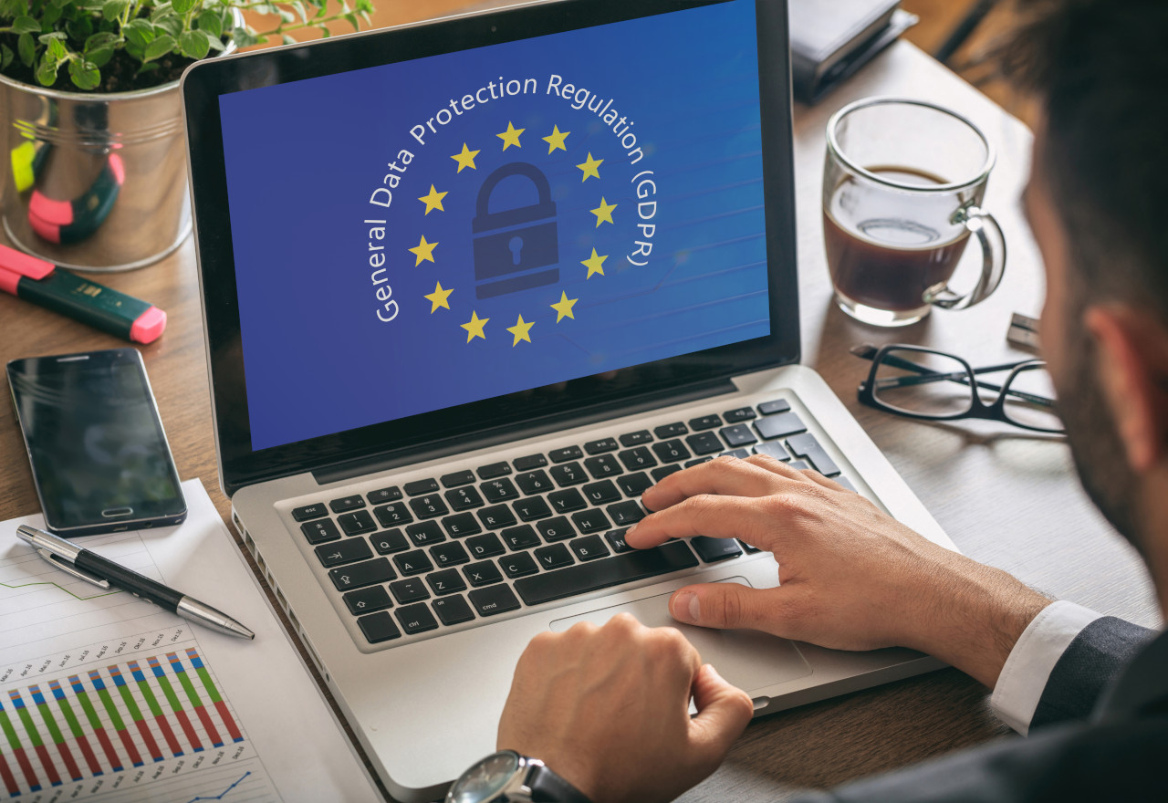 Man working with a computer, General Data Protection Regulation and European Union flag on the screen