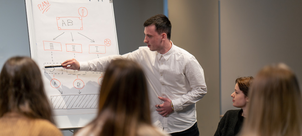 business conference or meeting in a hotel a man on a flipchart shows a development plan for the company